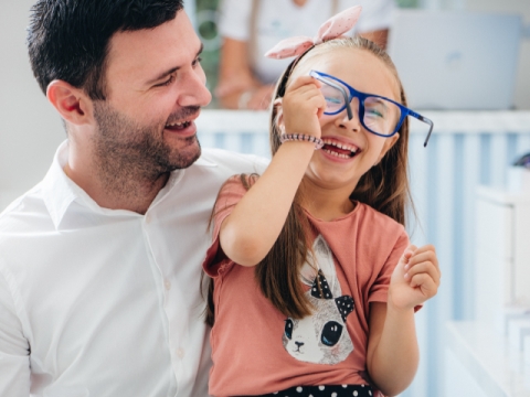 Father and daughter in optica store have a fun time